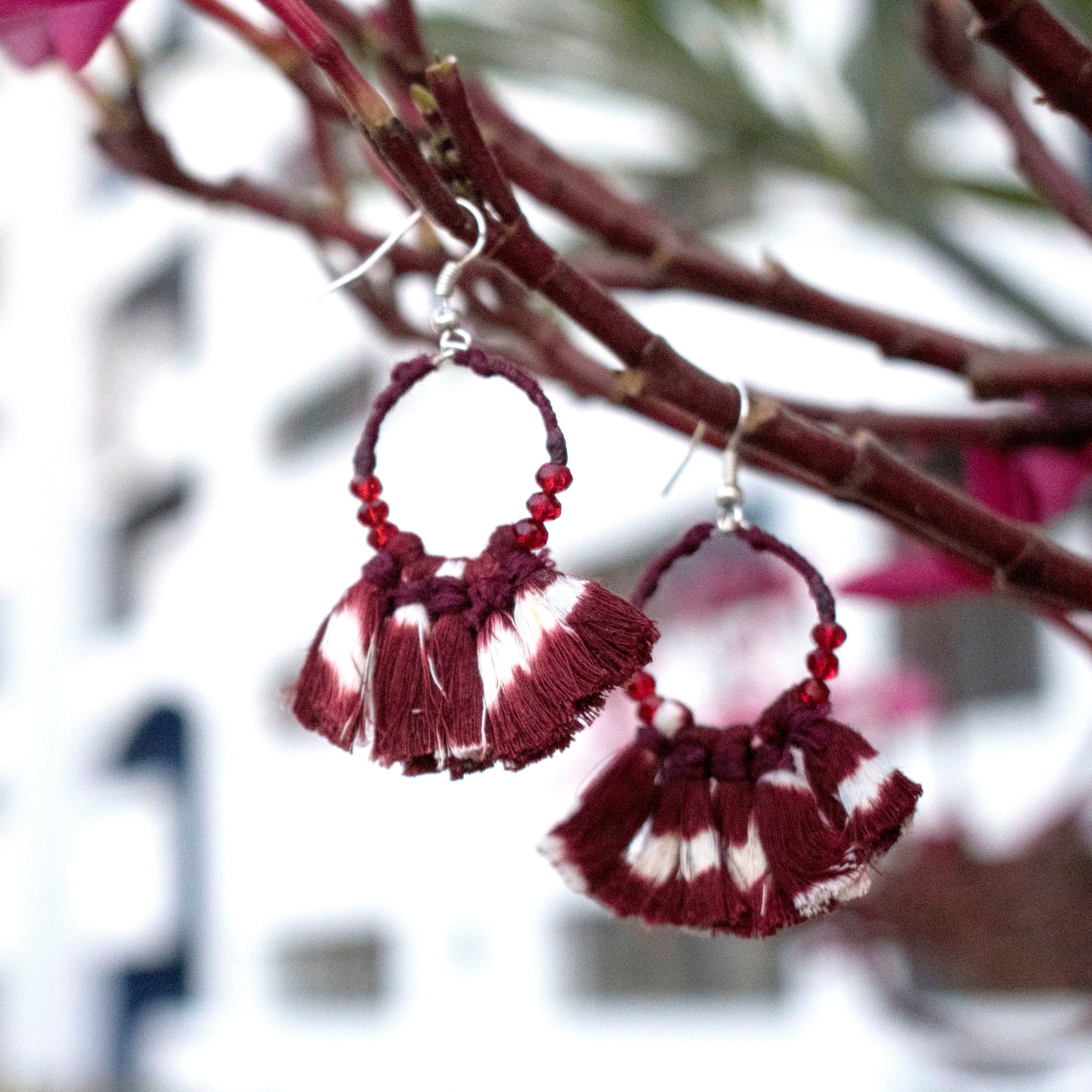 Earrings embellished with maroon ikat tassels and glass beads
