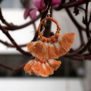 Handmade earrings embellished with orange ikat tassels and beads