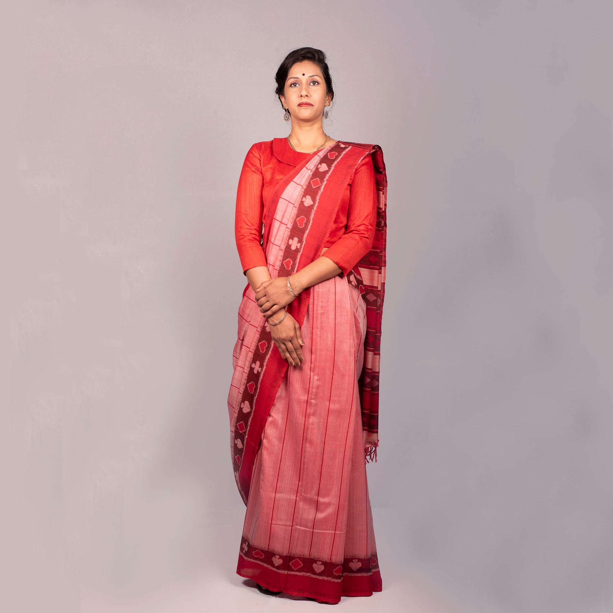 Handwoven pink, red and black ikat saree with taash border and bright red edges